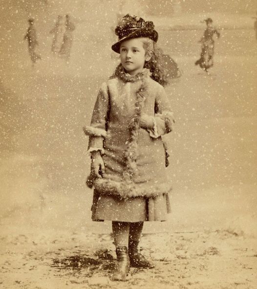 Young Beatrix Ferrand in black and white standing while the snow is falling.