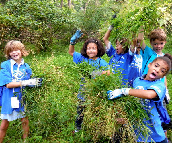 Children from Jellef Rec Center having fun while removing invasive grasses.